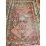 A Caucasian red ground rug, having three pole medallion to centre on a geometric ground,