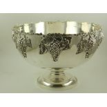 A large circular silver plated punch bowl, having moulded grape features.