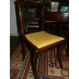 A set of four Regency style mahogany dining chairs, raised on sabre legs.