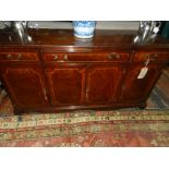 A 19th century style mahogany sideboard, having three drawers above four cupboard doors.