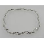 A white metal diamond set articulated link bracelet, stamped 375.