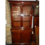 A Victorian mahogany bookcase, having two astral glazed doors above two cupboard doors. H.212cm W.