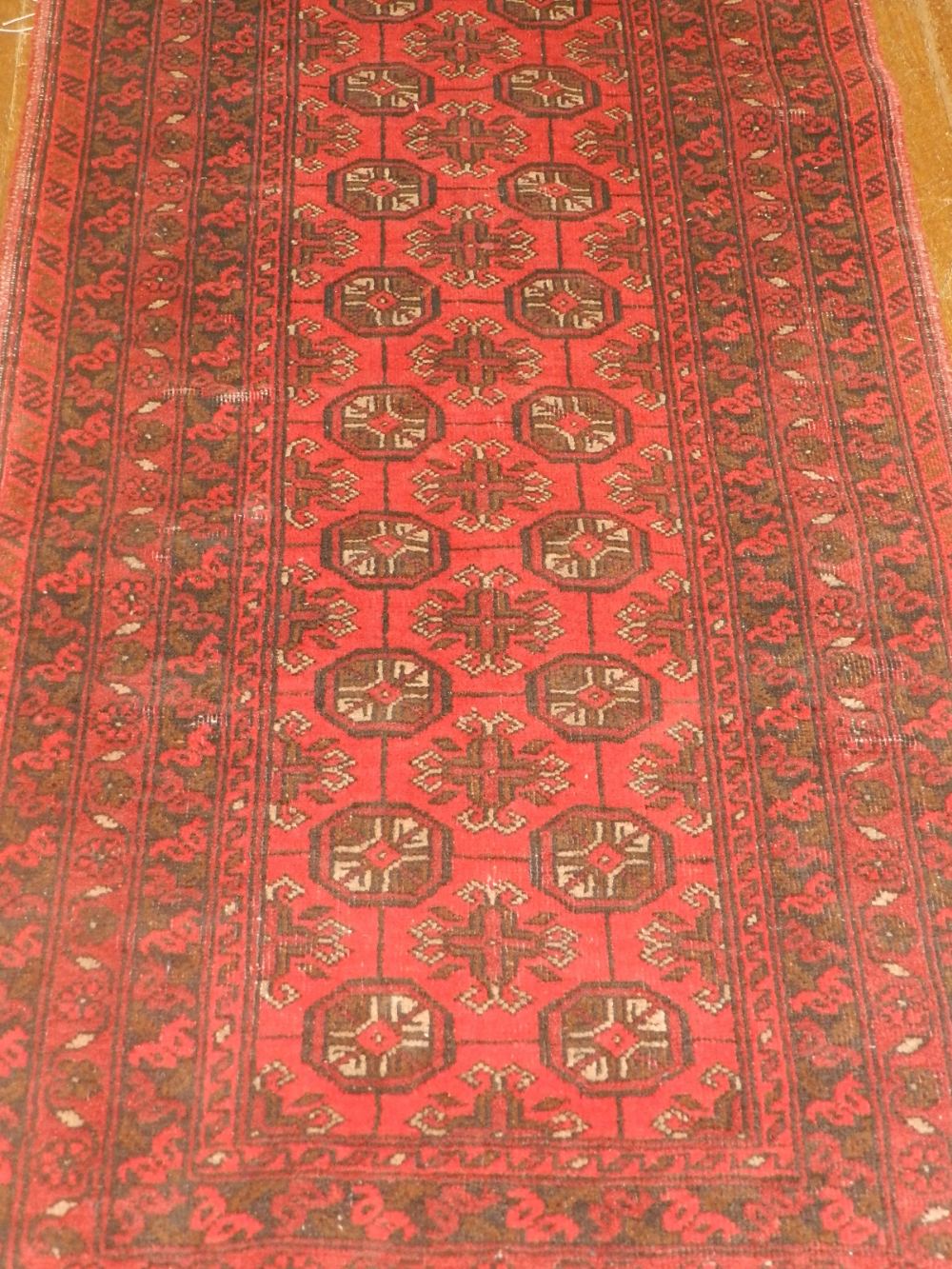 An Afghan Bokhara runner, having multi-medallions to centre within many borders, fringed. L.