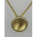 An 18ct yellow gold and diamond set and concave disk pendant,