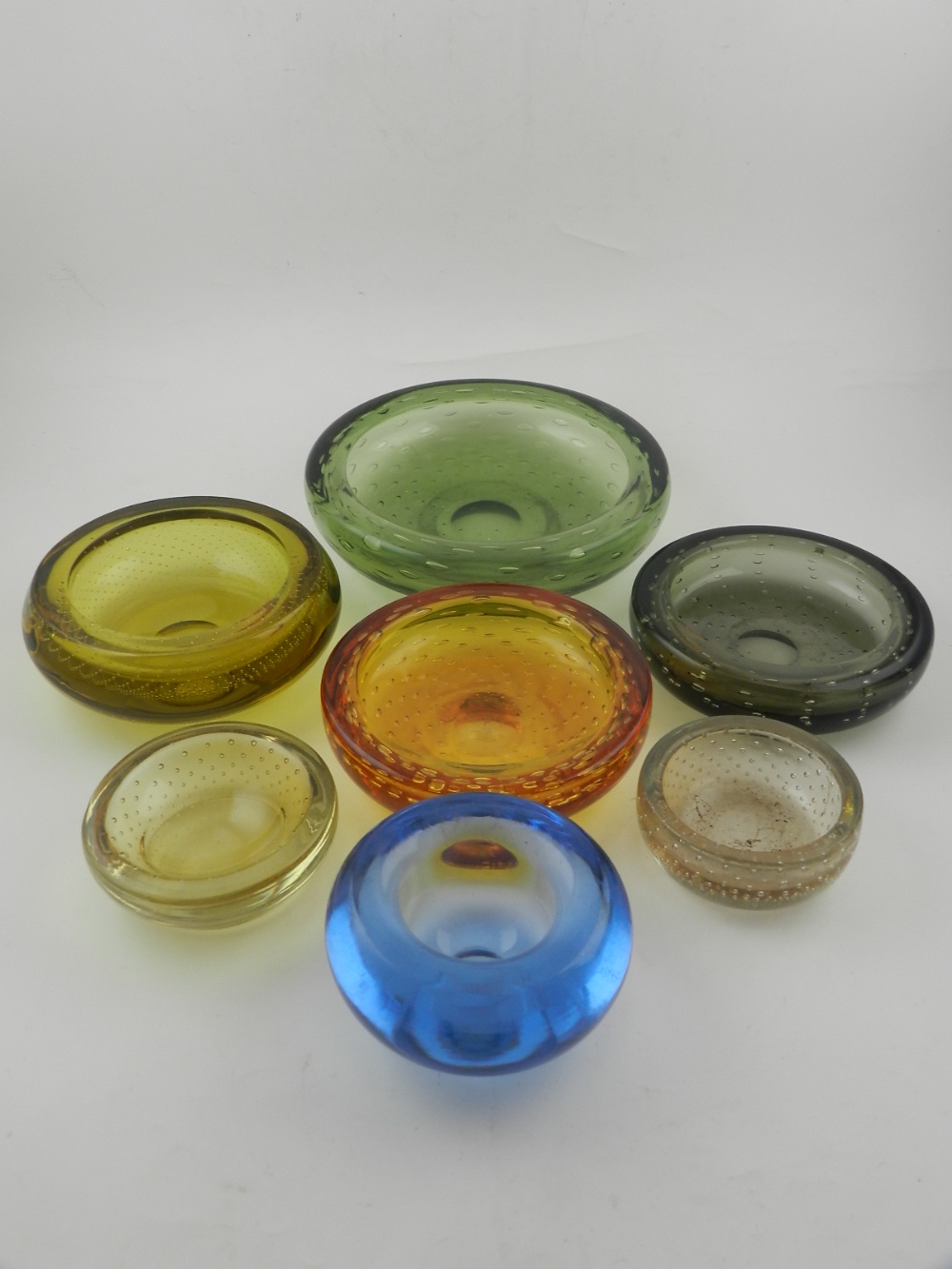 five Whitefriars glass ashtrays, together with two others.