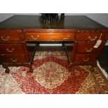 A 1920's inverted breakfront pedestal desk, having a green leather skiver. H.78cm W.150cm D.