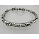 A 14 carat white gold and diamond bracelet, set alternating links of square cut and collet set