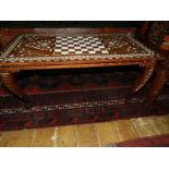 An Indonesian teak chess table, inlaid with bone. H.47cm W.89cm D.