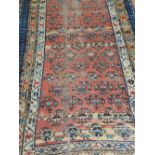 A Caucasian red ground rug, having multi medallions to centre within many borders. L.260cm, W.98cm.