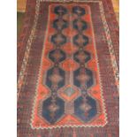 A Caucasian red ground rug, having two rows of six medallions to centre within many borders. L.