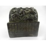 A Chinese bronze stamp, decorated with Chinese script and dragons. H.10cm