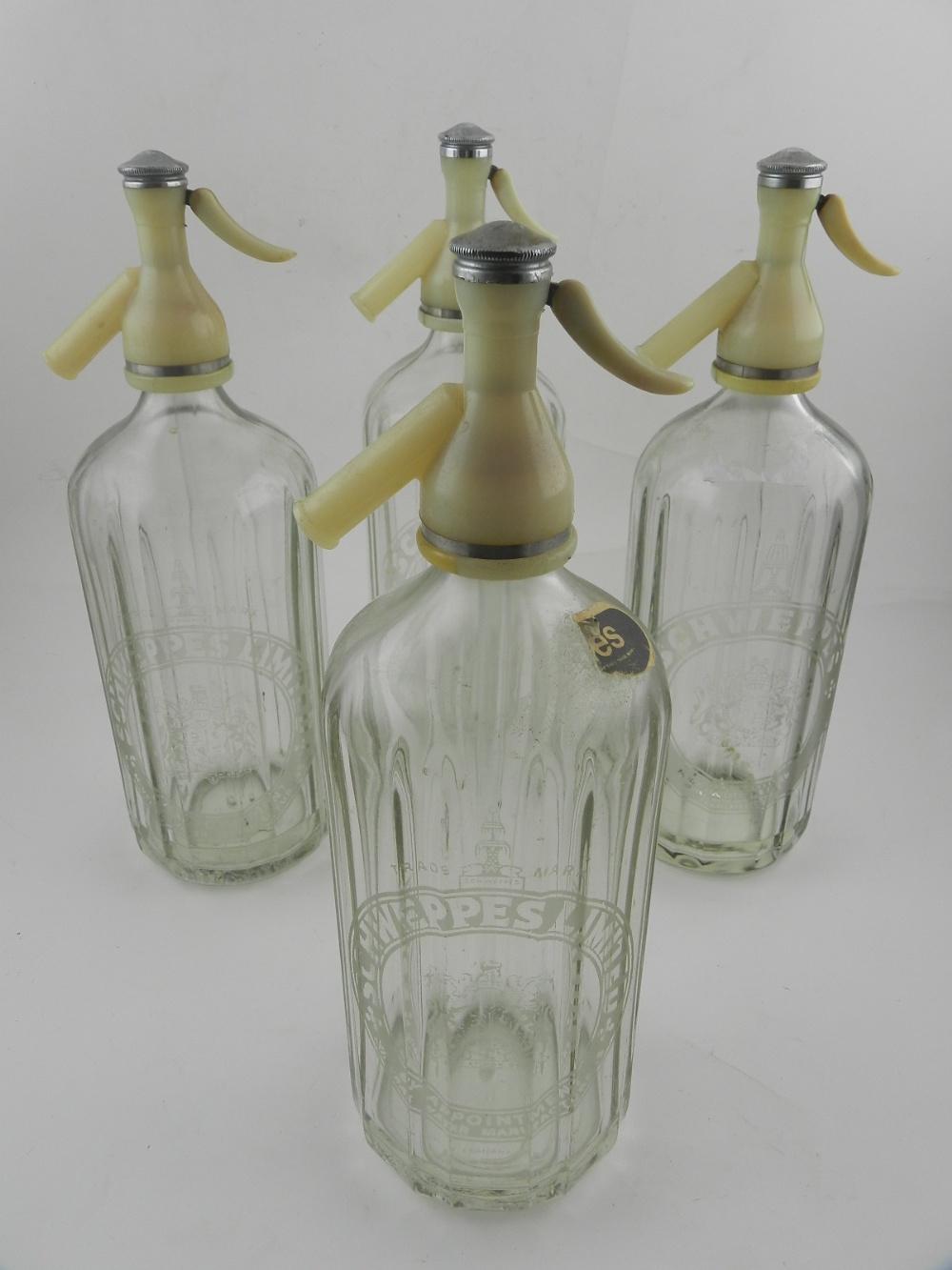 Four schweppes limited soda glass dispensers, together with six drinking glasses.