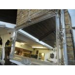 A large silver painted framed bevelled mirror. H.125cm W.