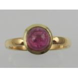 A 22ct yellow gold dress ring, centred with a ruby cabouchon.