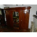 A Victorian mahogany triple door linen press, the central door having an arched bevelled plate