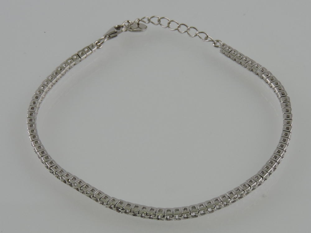 A white metal tennis bracelet, set with cubic zirconia and stamped 925.