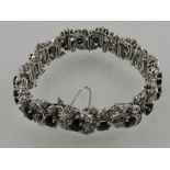 A 14ct white gold 20 stone sapphire and diamond articulated bracelet of flowerhead form,