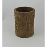 A carved bamboo brush pot, carved with figures below a tree, H. 18cm.