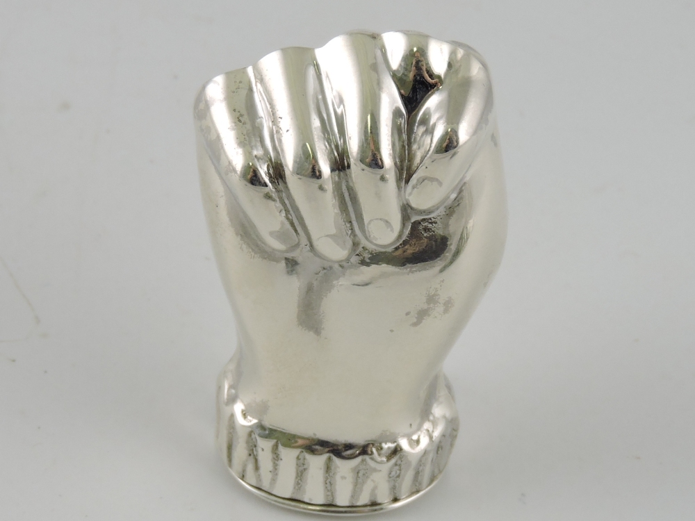 A white metal pill box in the form of a clenched fist, stamped 925, 18g.