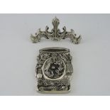 A white metal ink stand and cover, modelled with dragons, birds and buildings,