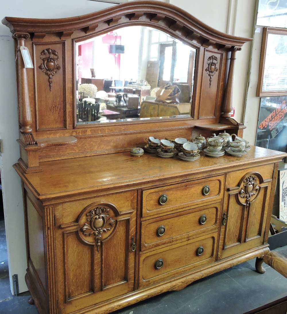 An Edwardian oak mirror back sideboard the arched plate flanked by ionic baluster pillars over 3