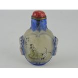 A reverse painted snuff bottle, decorated with a figure beside cranes,