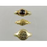 A yellow metal etruscan style signet ring with an engraved circular matrix,