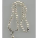 A freshwater pearl necklace, of uniform beads with a white metal knot incorporating a pearl pendant,