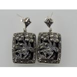 A pair of white metal ear drops, with floral decoration set with marcasites.
