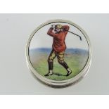 A circular white metal pill box stamped 925, the cover with an image of a vintage golfer, 16g.