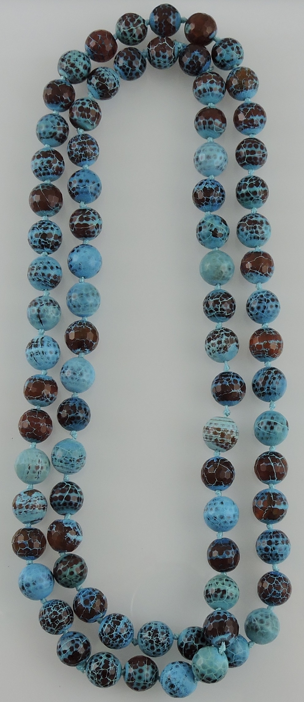 A necklace comprising uniform turquoise and brown coloured beads, L. 118cm.