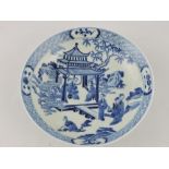 A blue and white Qing style dish, decorated with figures under a pagoda,