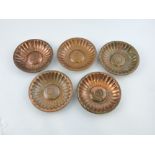 A set of five Newlyn copper dishes, with a domed centre and radiating fluted pattern, D. 14cm.