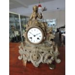 An early 20th Century cast gilt spelter mantel clock with circular white enamel dial