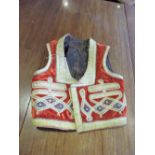 An Indian red velvet polychrome silk thread embroidered waistcoat