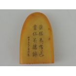 An amber coloured soapstone seal, decorated with character marks, H. 6cm.