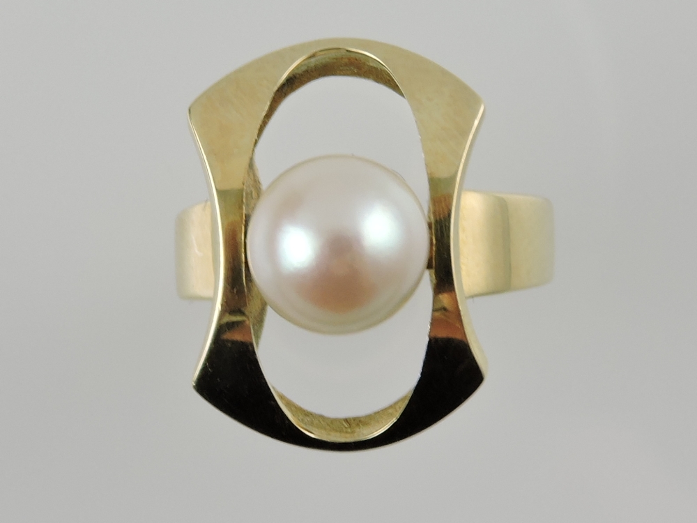 A retro cultured pearl dress ring, set within a yellow metal bow and band stamped 585.