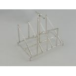 A white metal six division toast rack, in the manner of Christopher Dresser, with ball and bar knop,