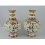 A pair of Chinese reticulated vases, of bulbous baluster form and decorated with trailing foliage,