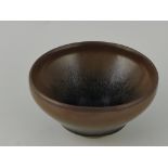 A jian kiln style tea bowl, of brown and blue glazes raided on an unglazed foot, D. 11cm.