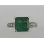 An 18ct white gold emerald and diamond dress ring, in the Art Deco taste,