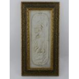 A framed limestone plaque depicting a Classical female and cherub.