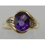 A yellow metal and amethyst set ring crossover ring, the shoulders channel set with small diamonds,