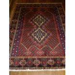 A red ground Keshan rug, having diamond medallion on geometric patterned ground,