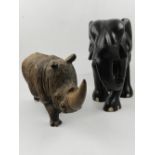 An East African carved ebony elephant, together with a carved treen study of a white rhino. H.