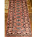 An Afghan Bokhara runner, having elephant pad medallions to centre, multi-bordered and fringed. L.