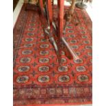 A red ground Turkmen rug, having five rows of elephant pad motifs to centre,