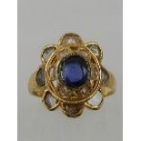 A yellow metal, sapphire, and diamond cocktail ring, set eight old cut diamonds,