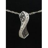A 9 carat white gold, black and white diamond set pendant, suspended on a 9 carat white gold chain.