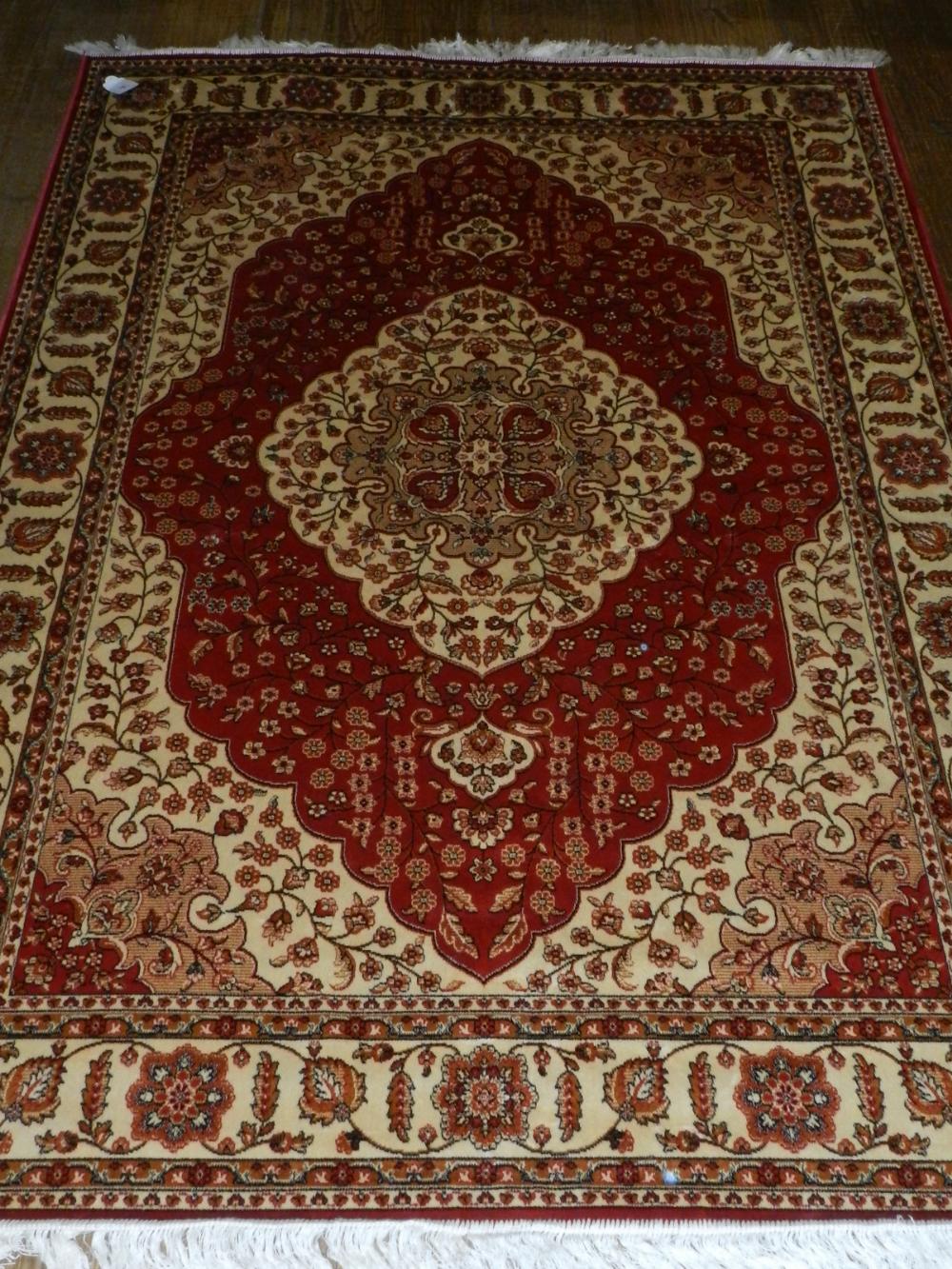 A Persian style red ground Kum carpet, having quatrefoil medallion to centre,